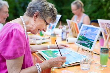 senior woman smiling as she paints